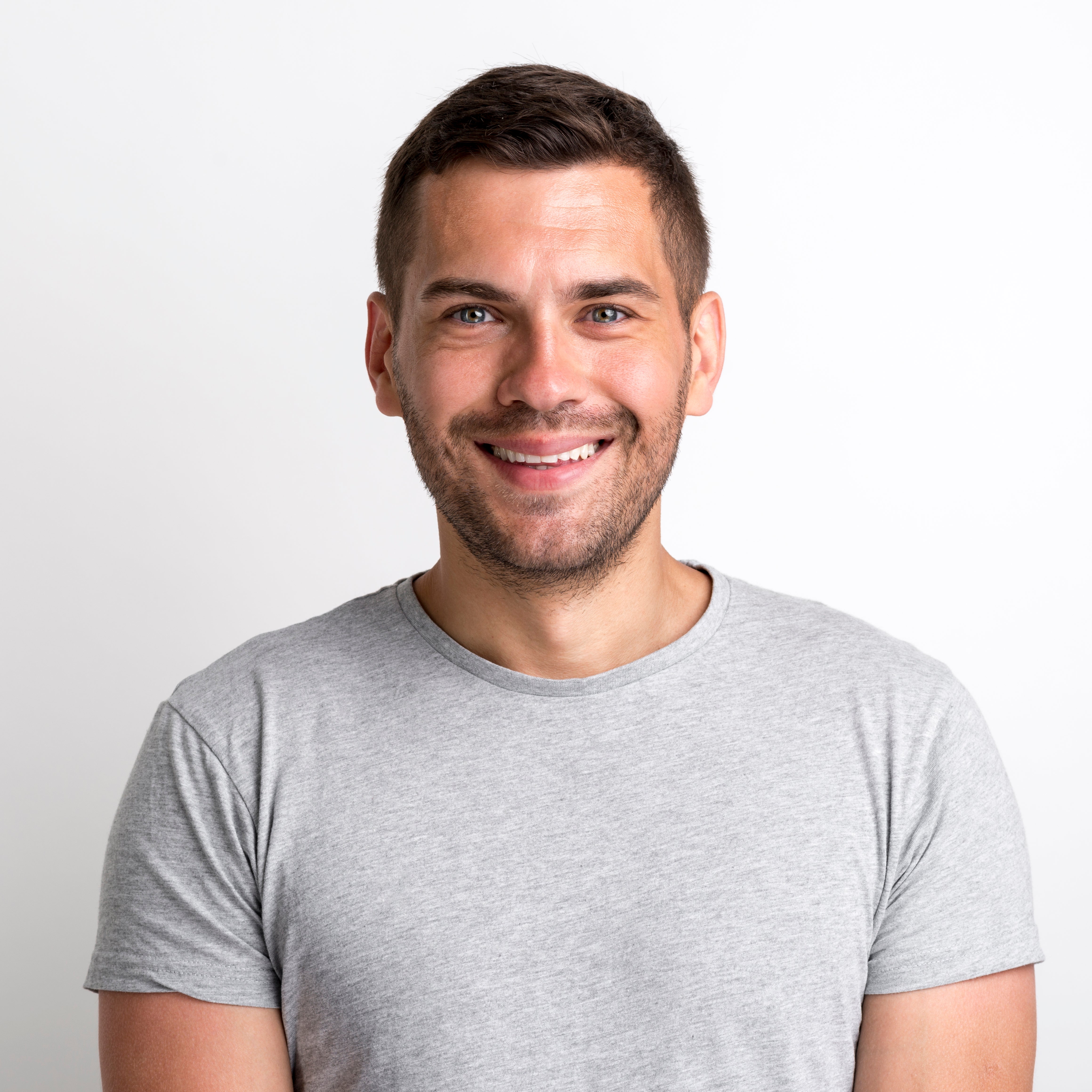 files/portrait-smiling-charming-young-man-grey-t-shirt-standing-against-plain-background.jpg