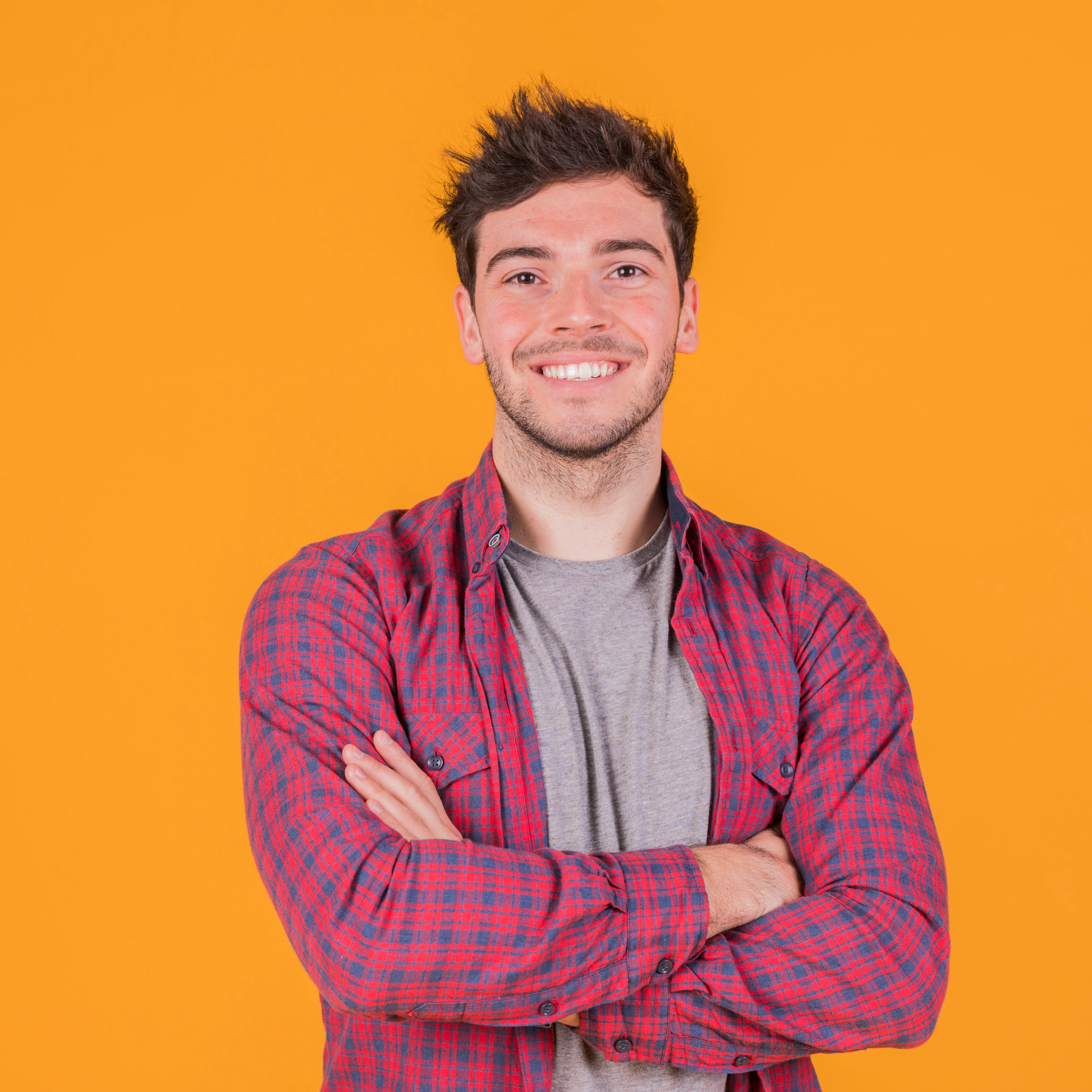 files/portrait-smiling-young-man-with-his-arm-crossed-standing-against-orange-backdrop.jpg
